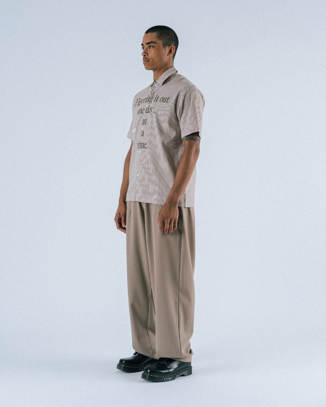 Man wearing a beige shirt and pants on a white background