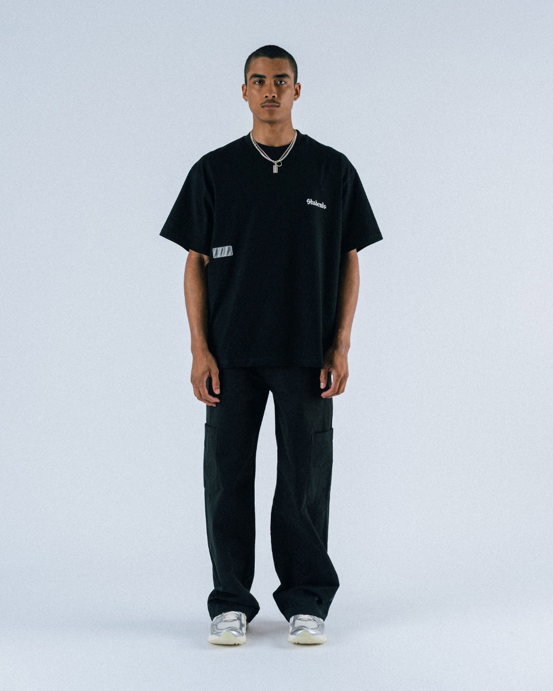 Person wearing a black t-shirt and pants on a white background