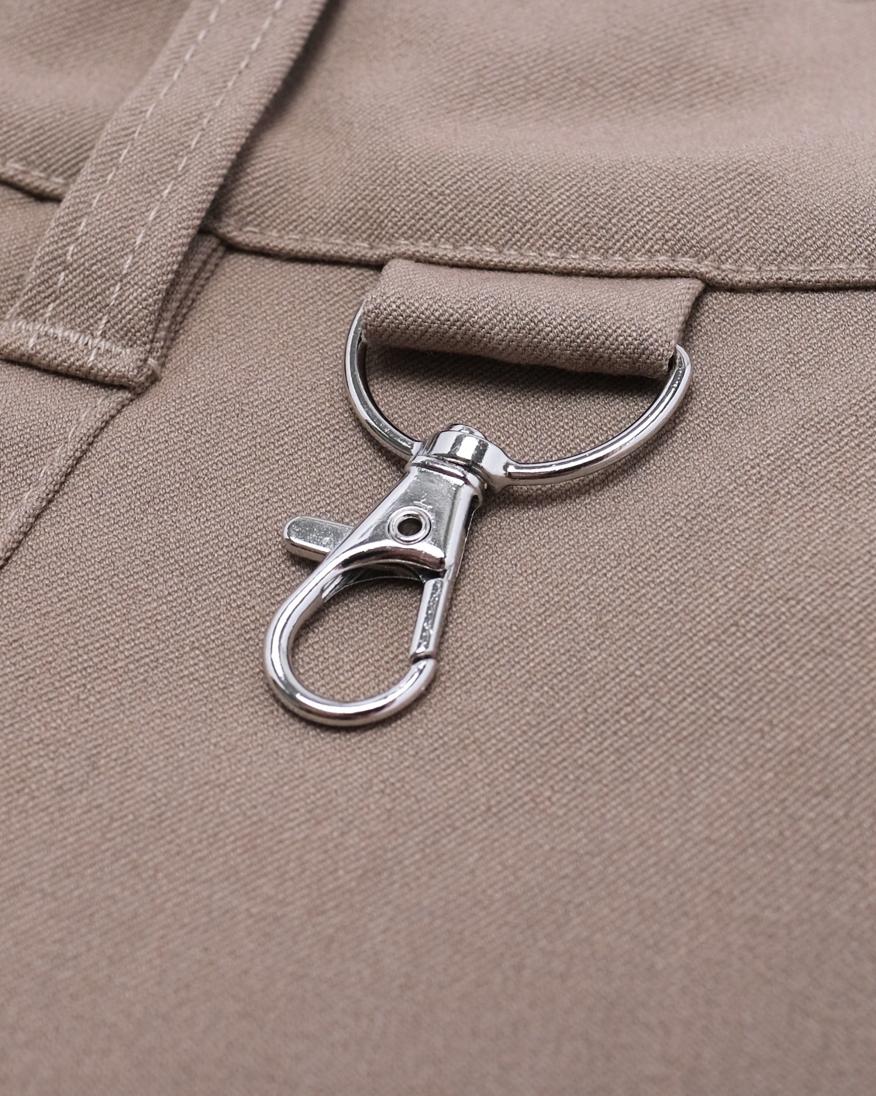 Close-up of a metal clasp on a beige fabric background