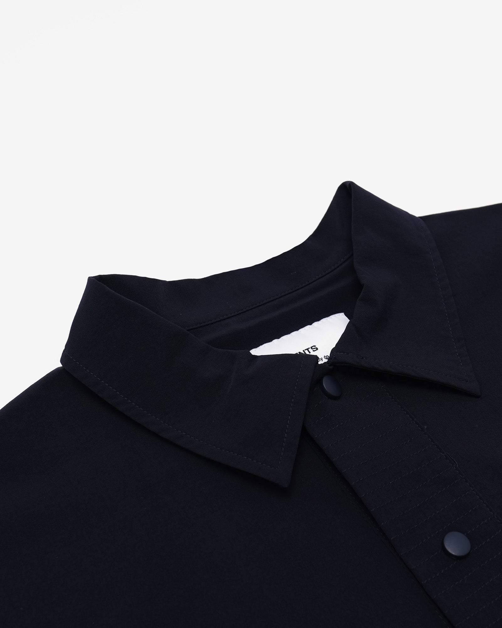 Close-up of a shirt collar with buttons on a light gray background