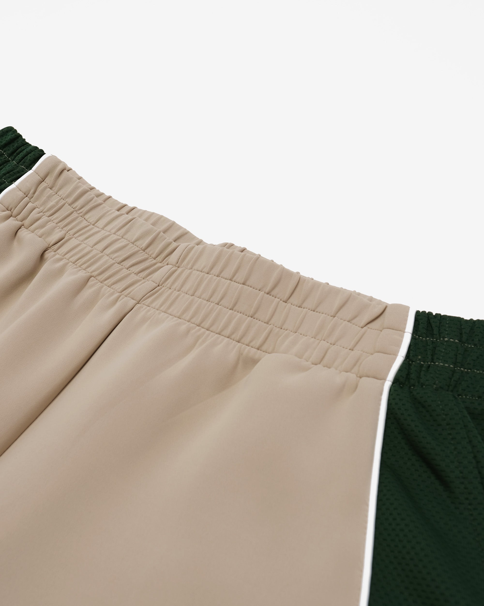 Close-up of beige and green pants with a white background