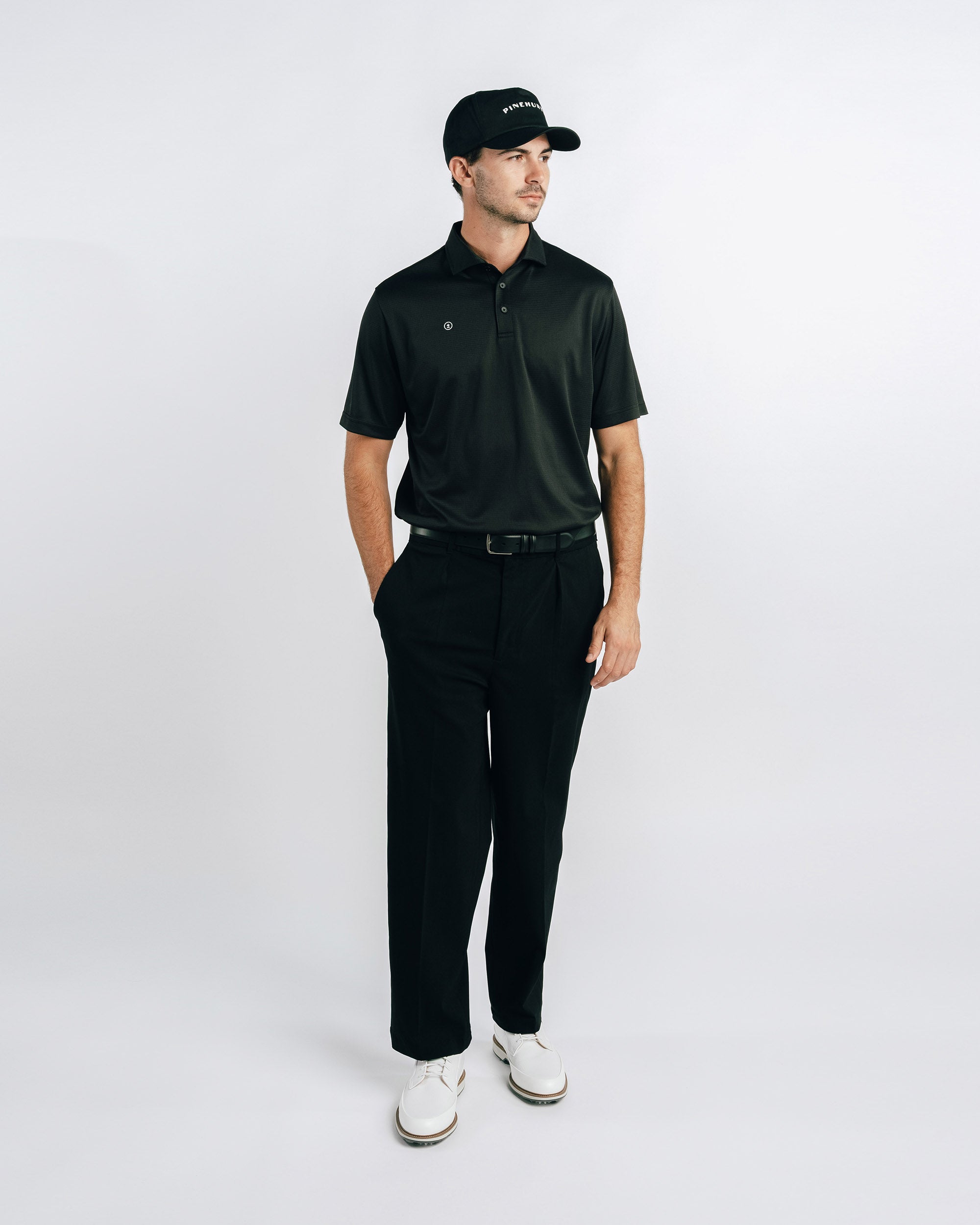 Man wearing a black outfit with a cap on a white background