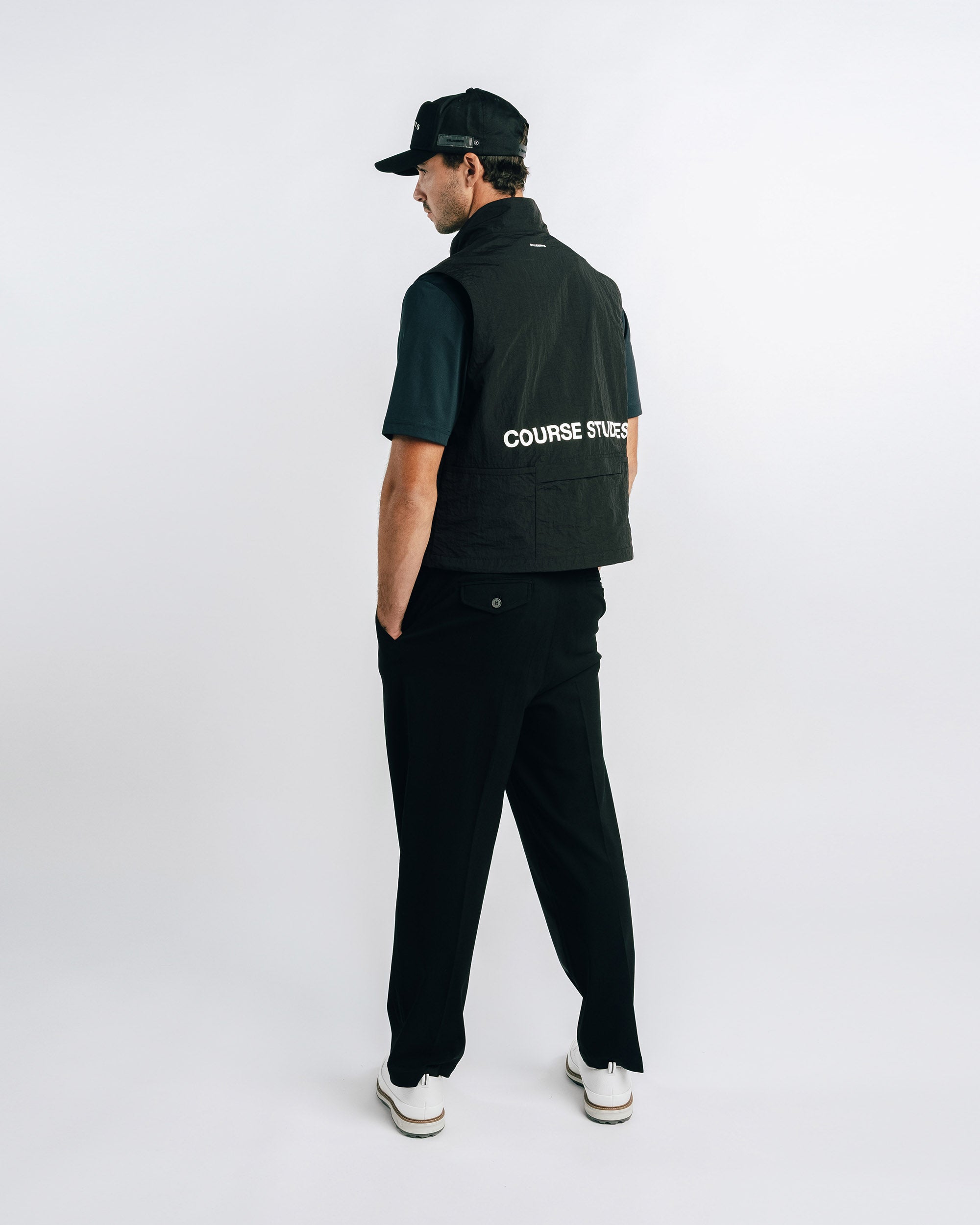 Person wearing a black jacket with 'COURSE STUDIES' branding on a white background