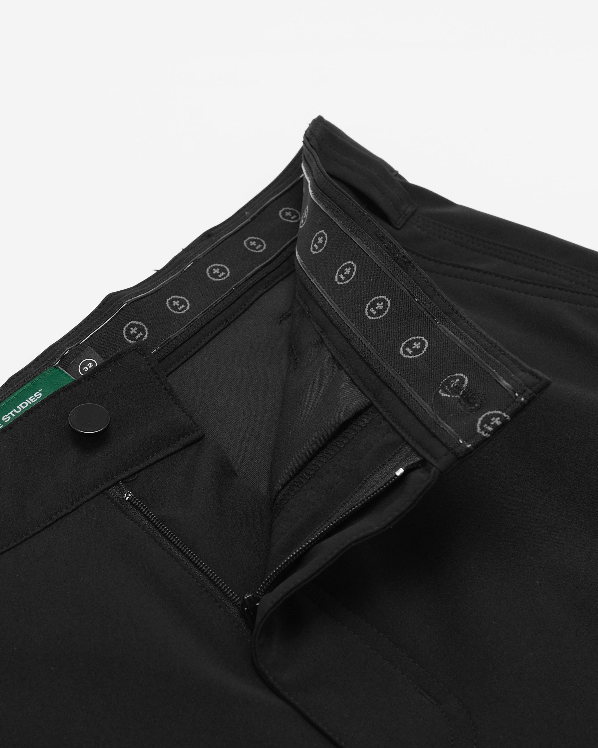 Close-up of black pants with button details on a white background