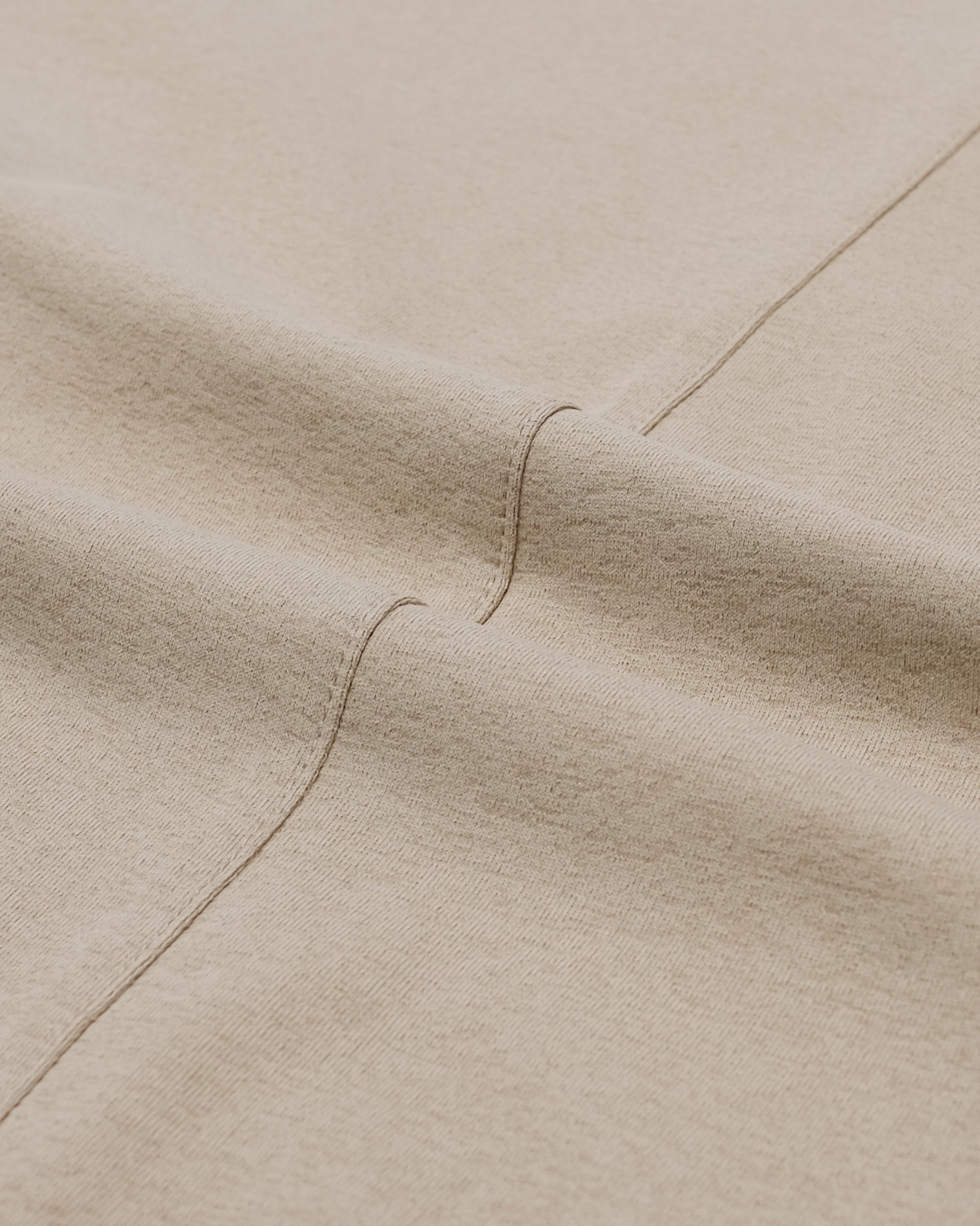 Close-up of beige fabric with a visible seam