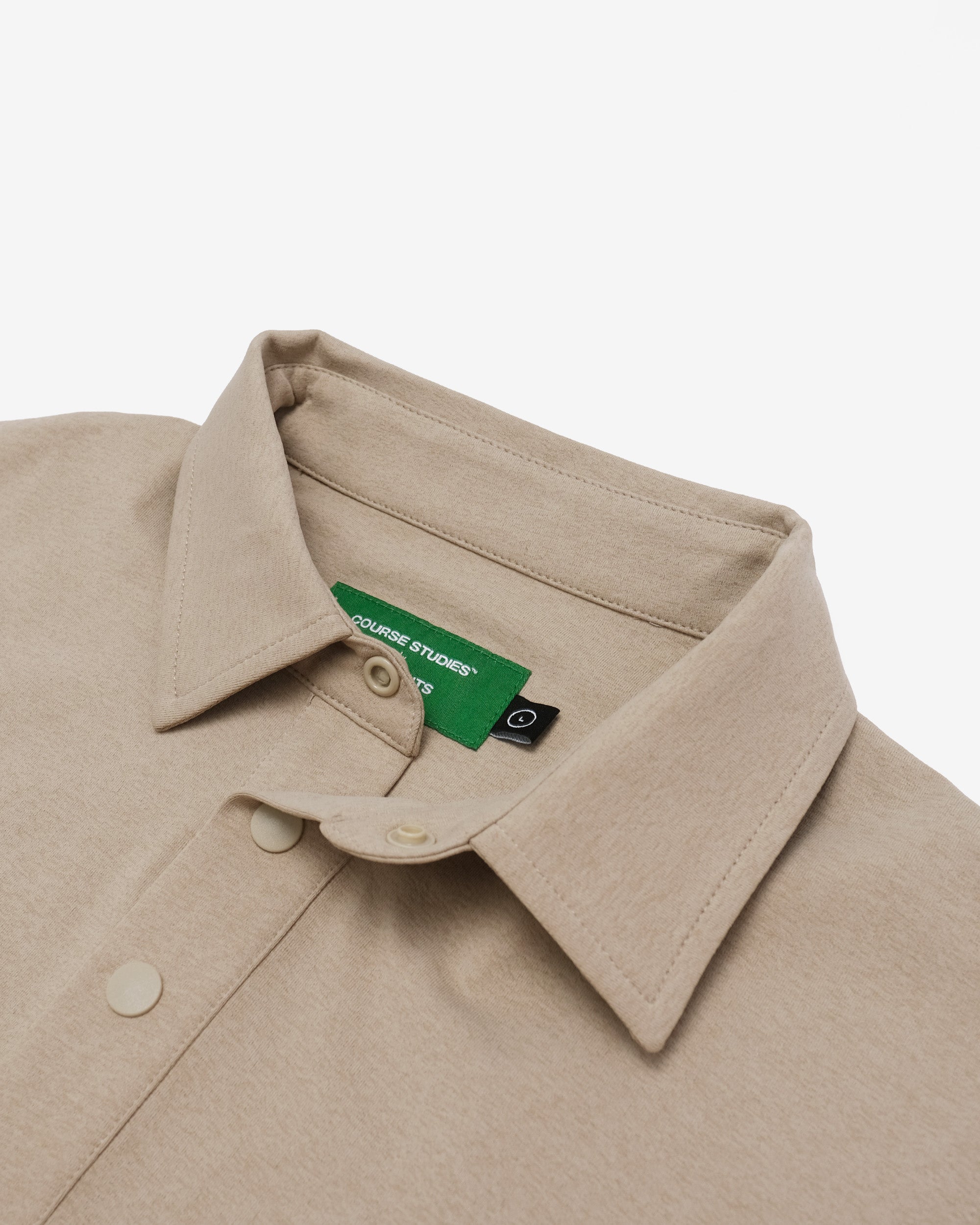 Close-up of a beige shirt collar with a brand tag on a white background