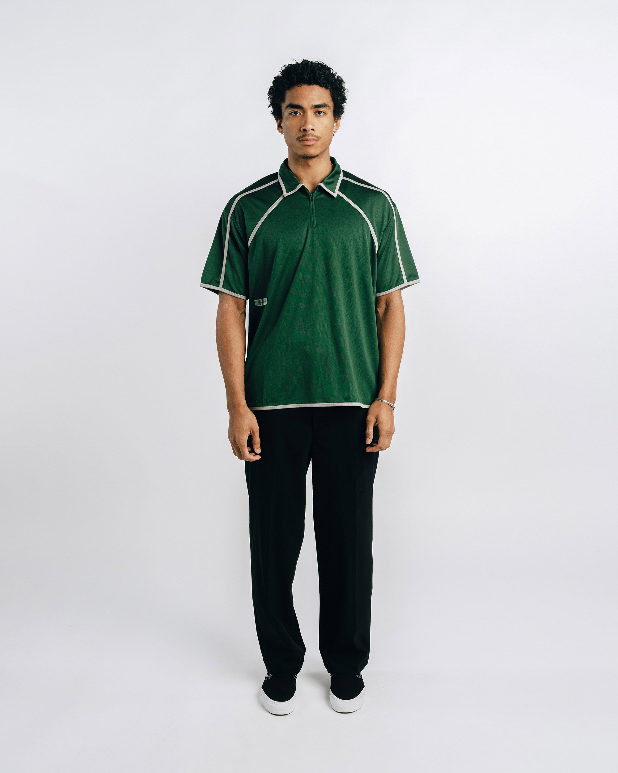 Person wearing a green and black sports outfit on a white background