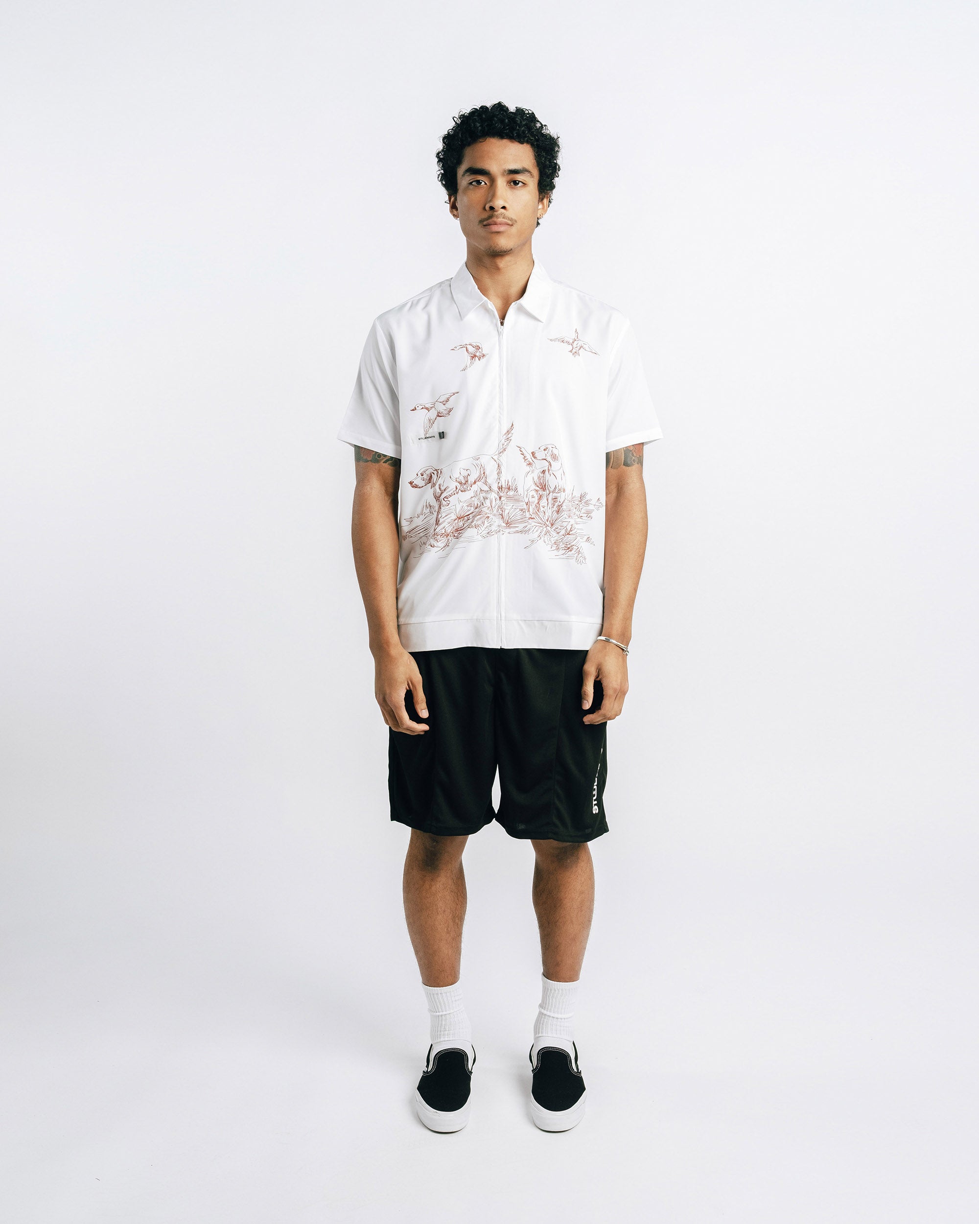 Person wearing a white shirt with black shorts on a white background