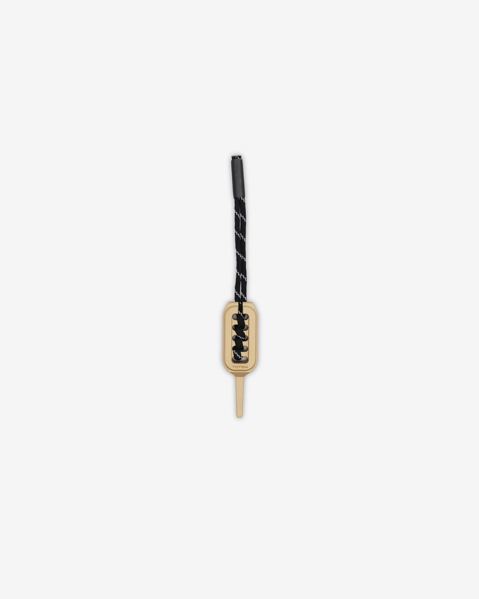 Divot with black cord and gold clasp on a white background