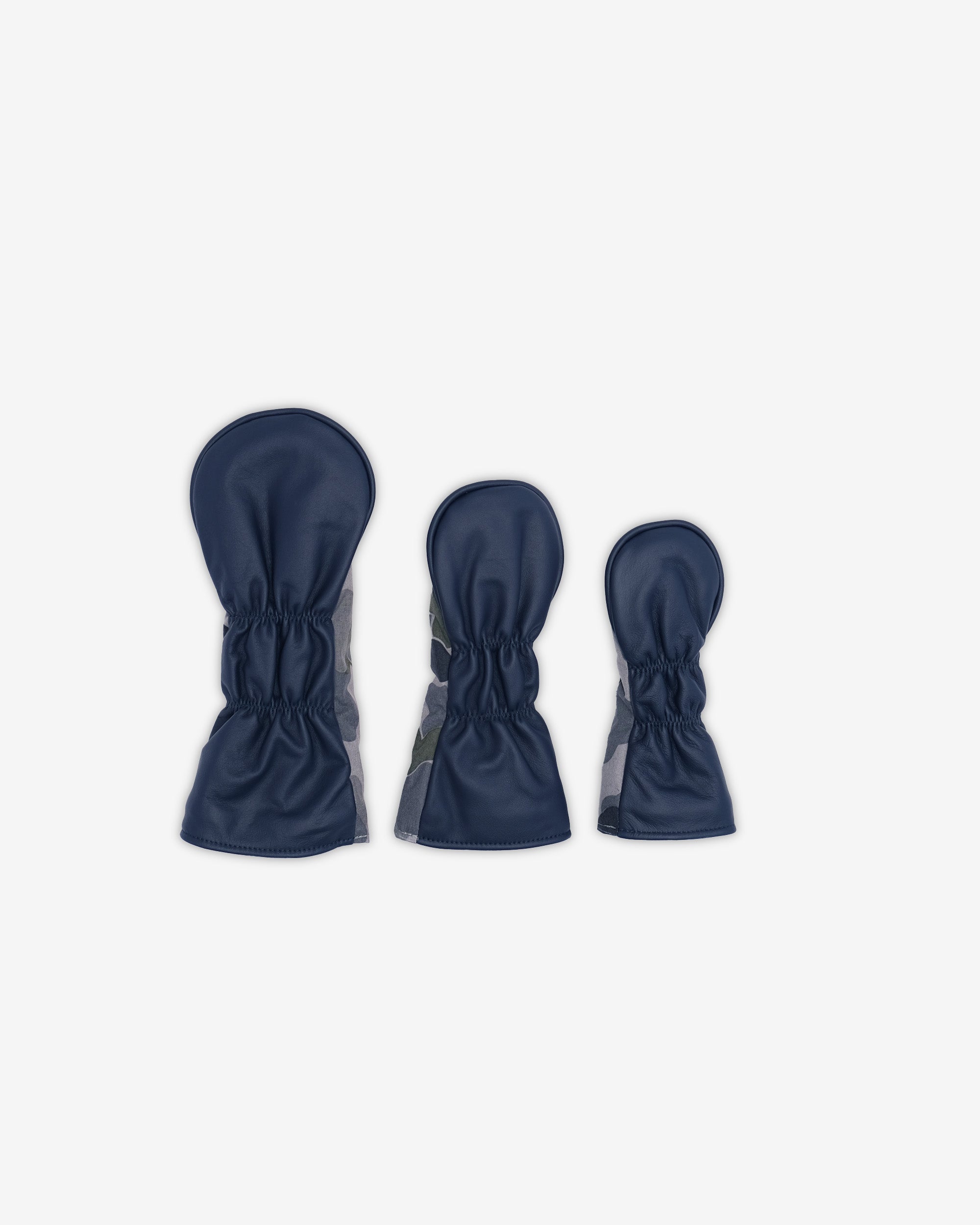Three pairs of navy blue golf club covers on a white background