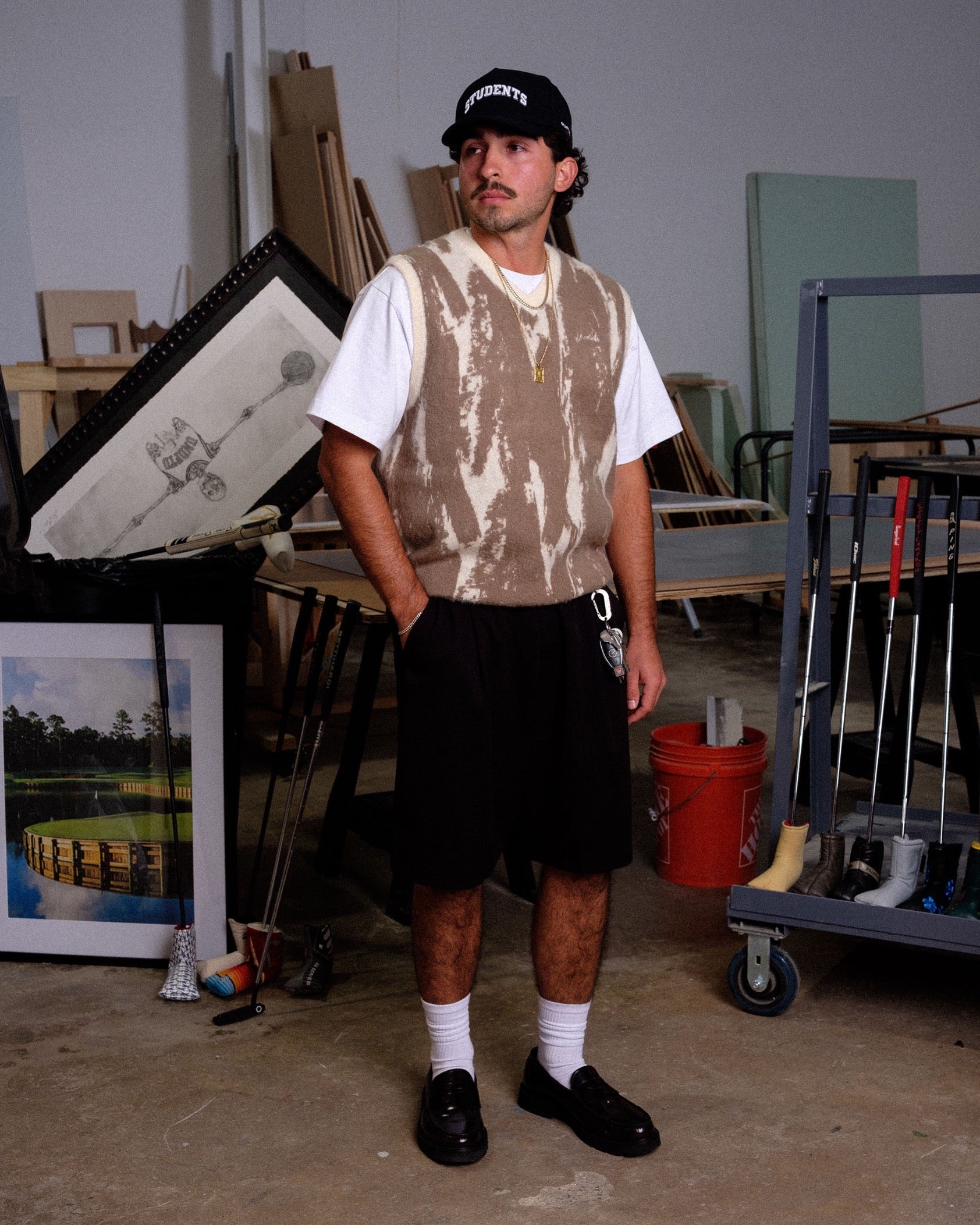 Man standing in a storage or warehouse area with various items in the background
