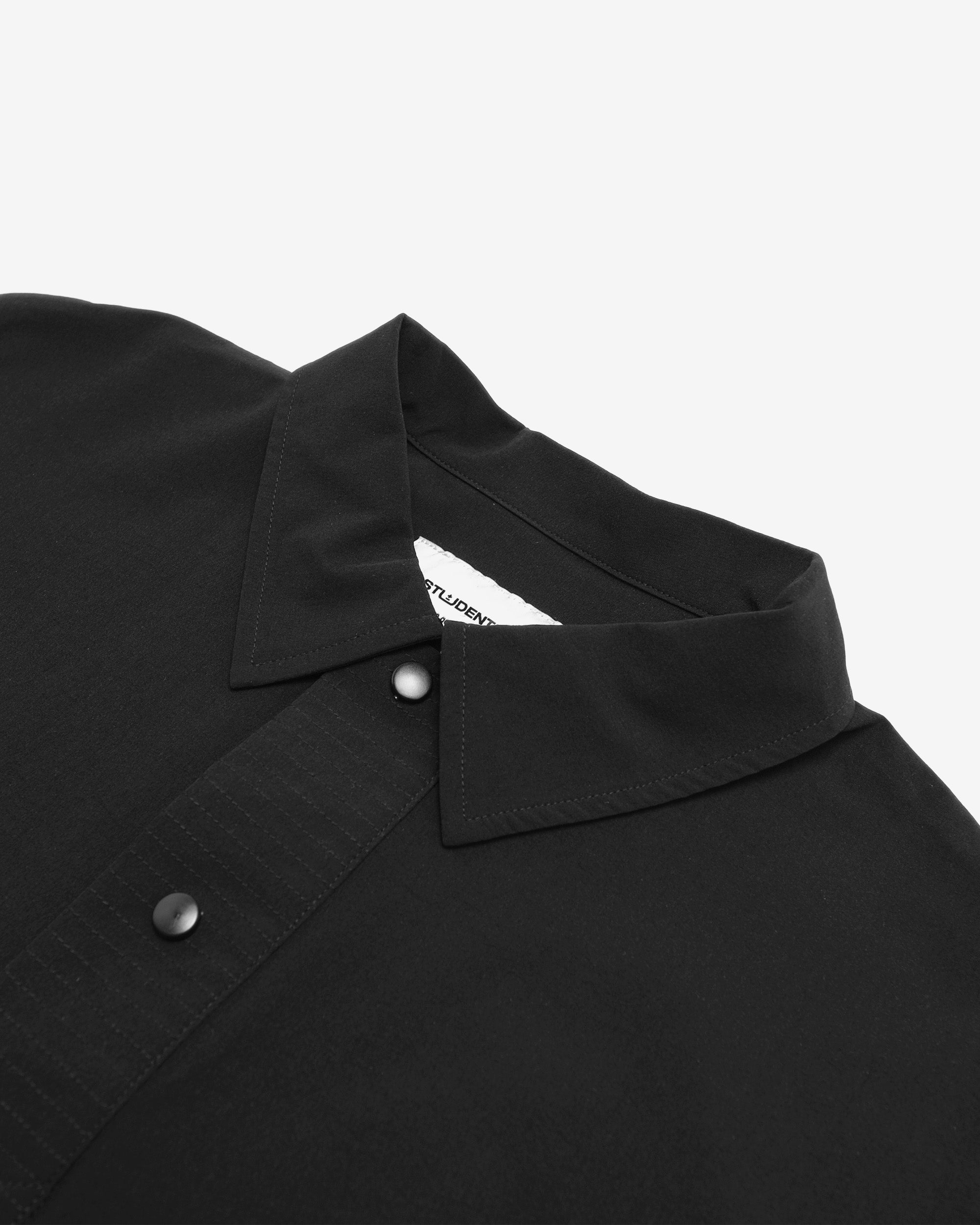 Close-up of a black shirt collar with a brand label on a white background