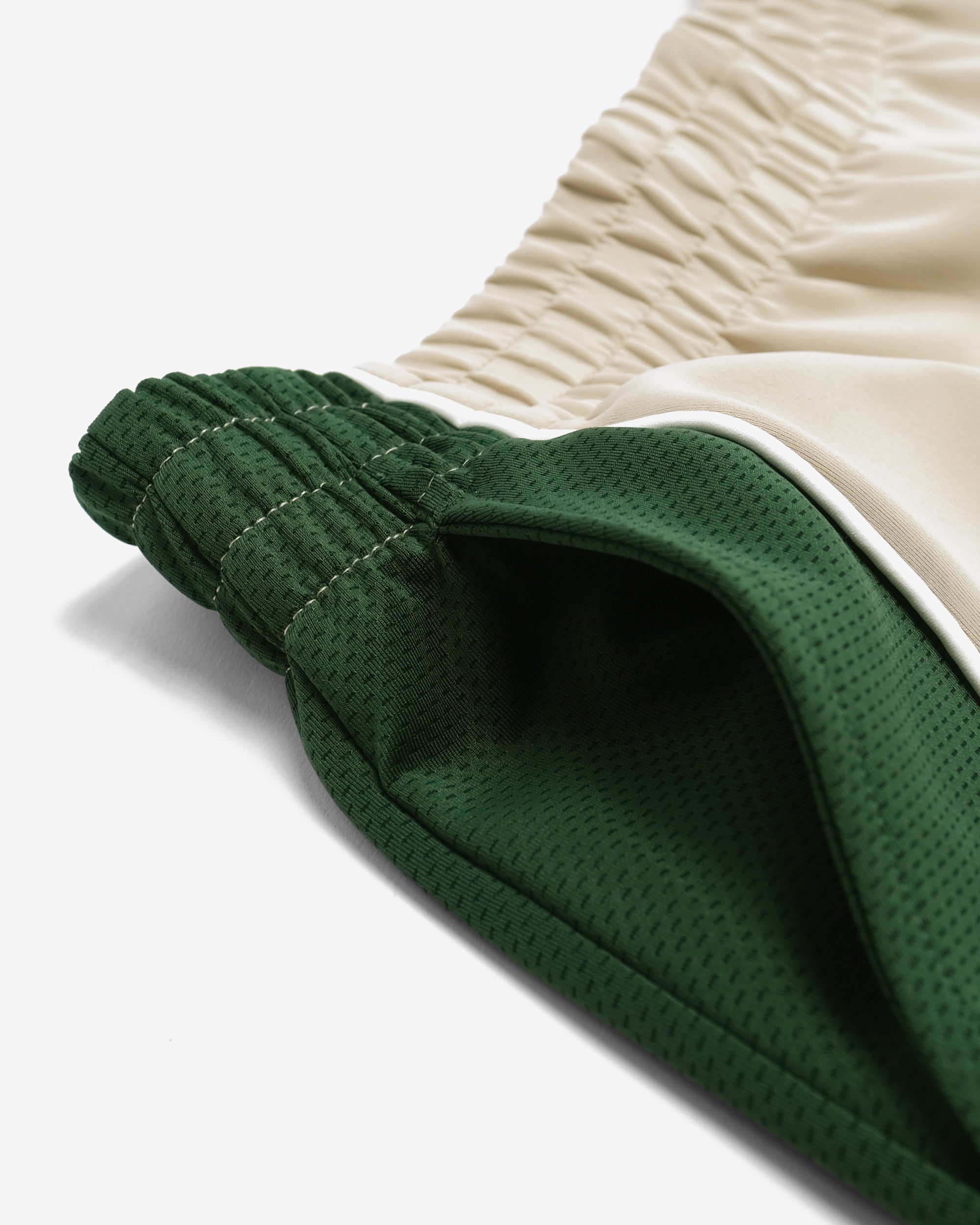 Close-up of green and beige fabric with a textured pattern on a white background