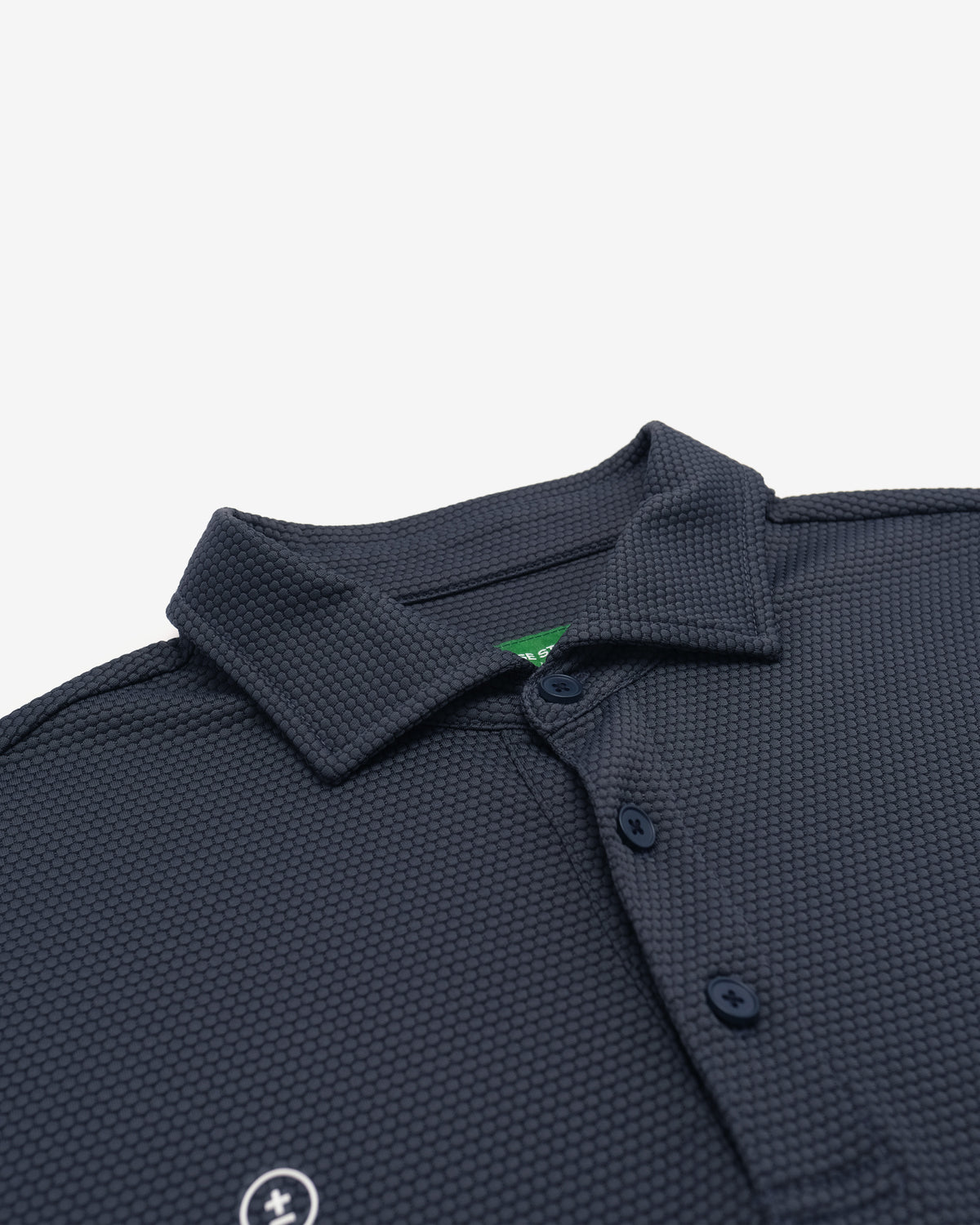 Close-up of a dark navy textured polo shirt collar and button placket on a light gray background.