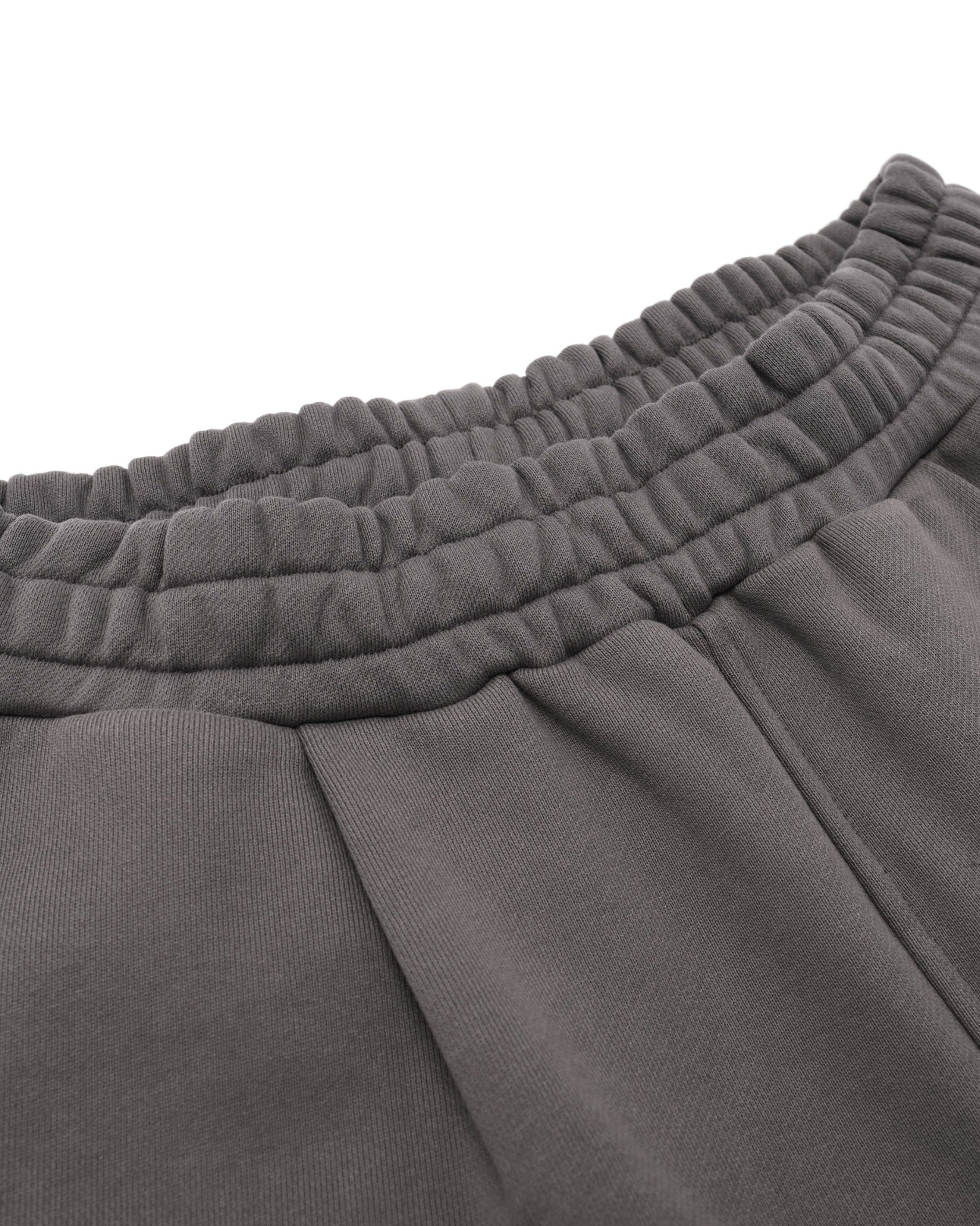 Close-up of gray sweatpants with a focus on the waistband.