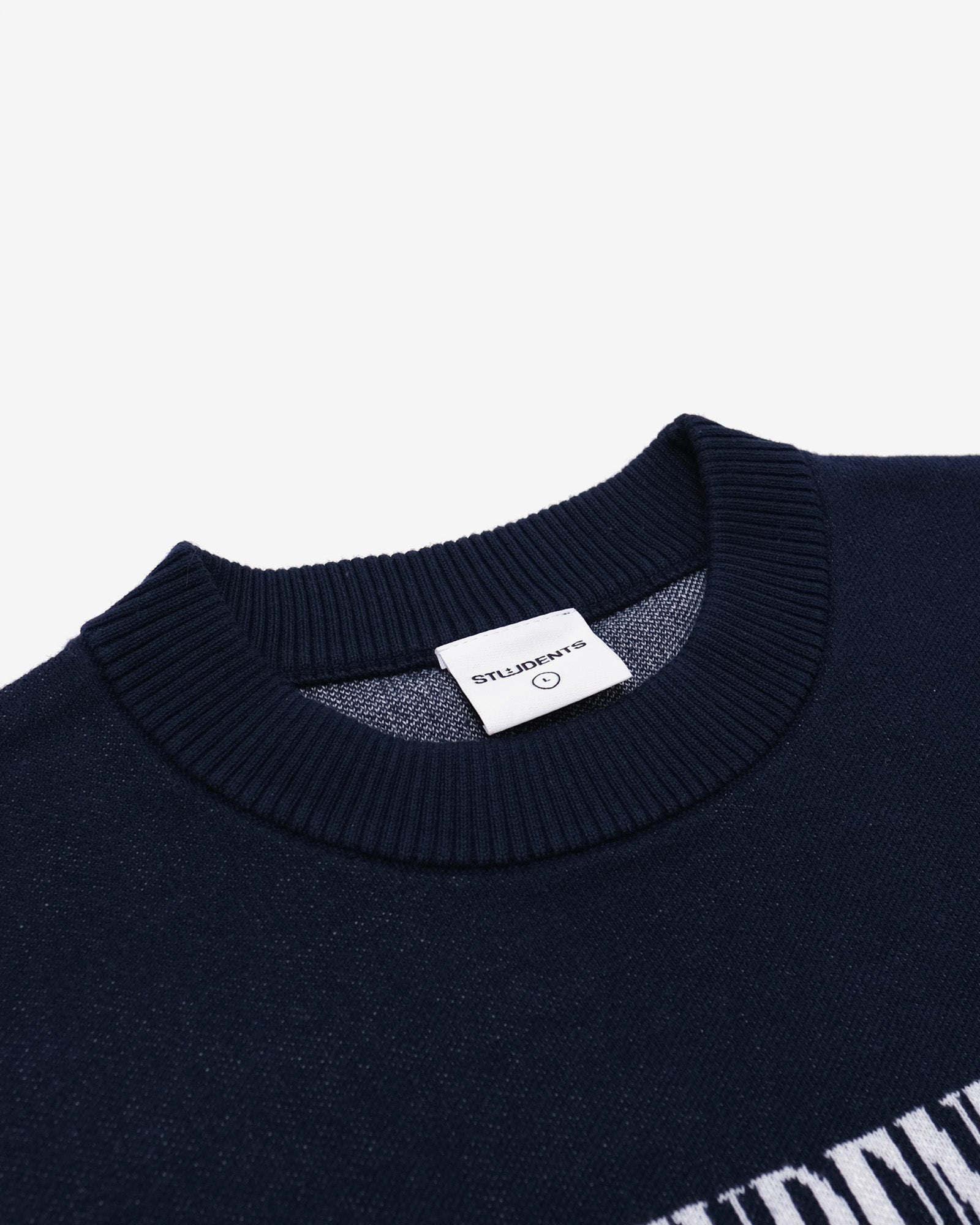 Navy blue sweater with a brand label on a light gray background