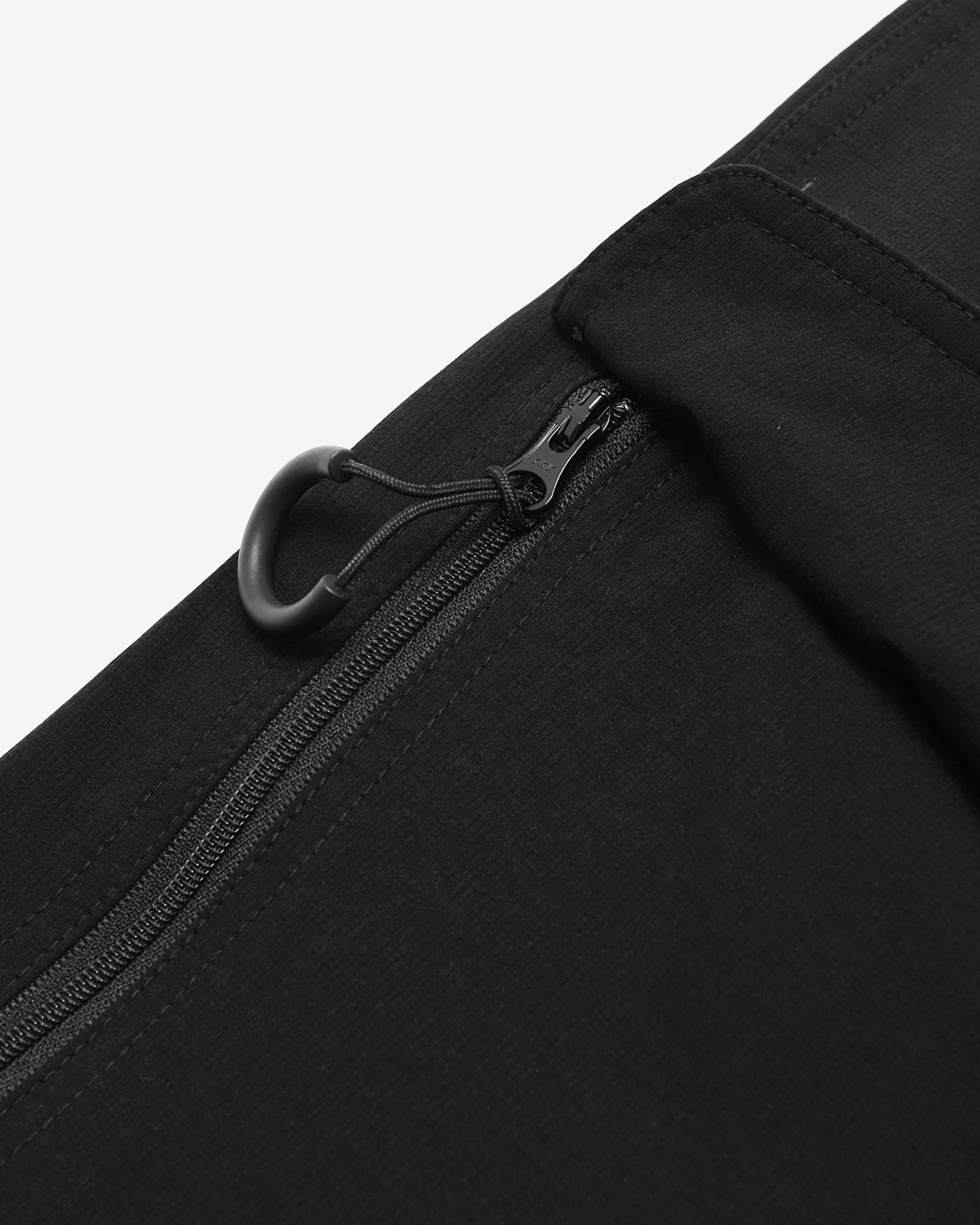 Close-up of a black zipper on a black garment against a white background