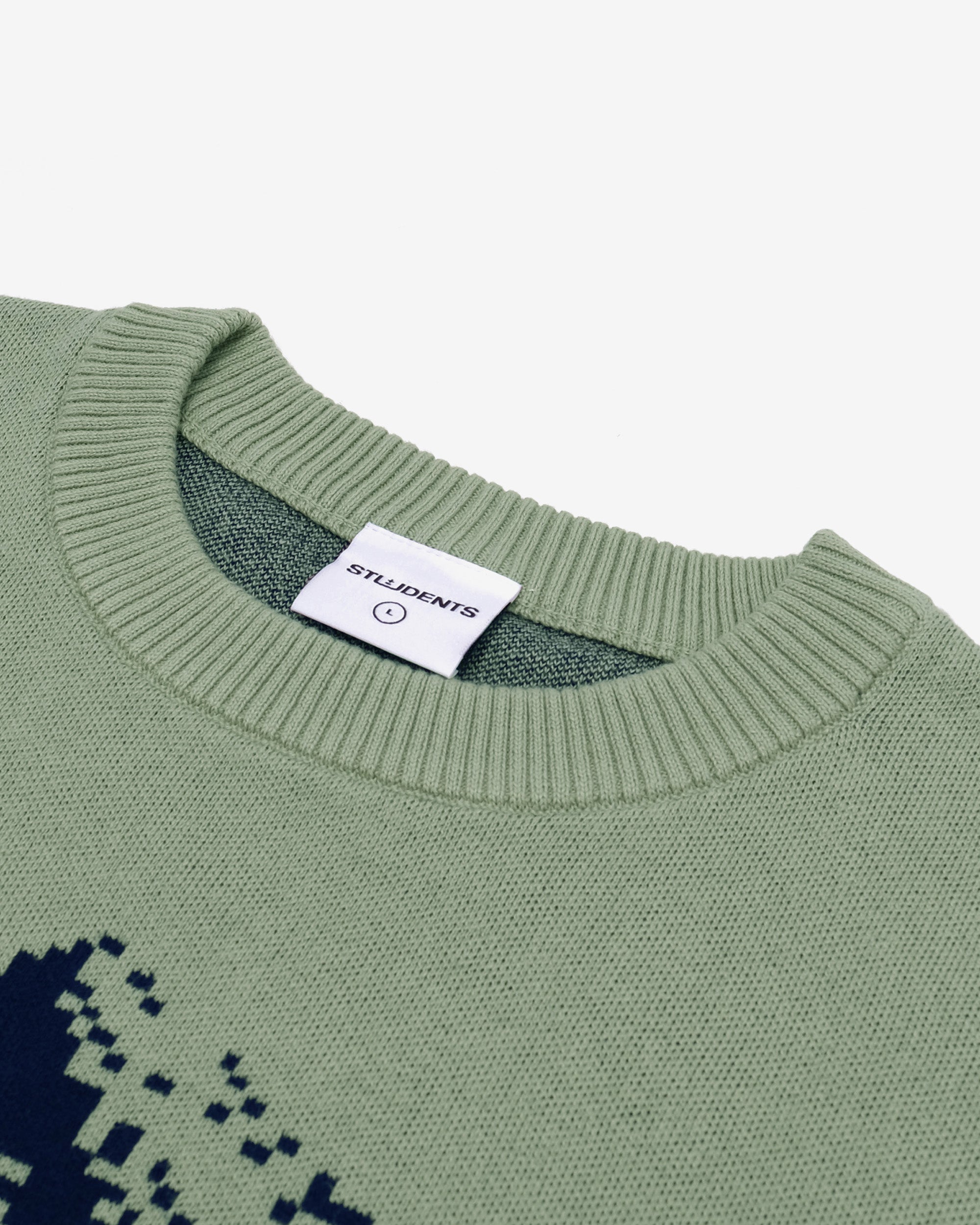 Green sweater with a pixelated design and 'STUDENTS' label on a white background