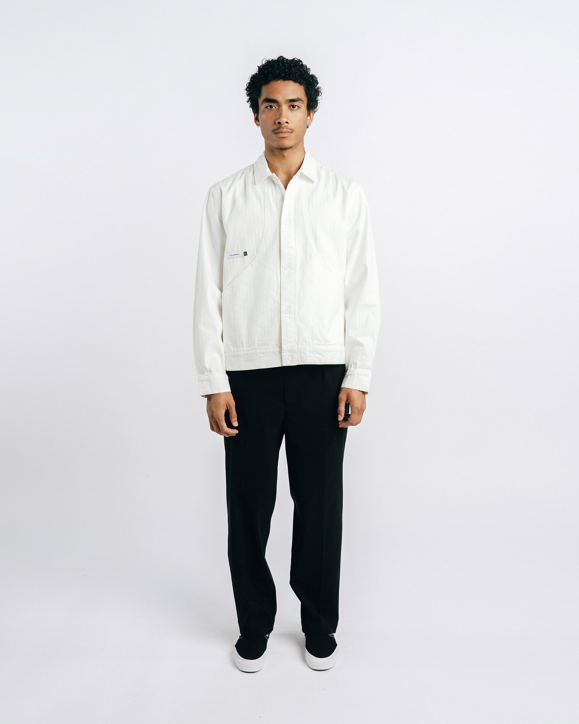 Man wearing a white shirt and black pants on a white background