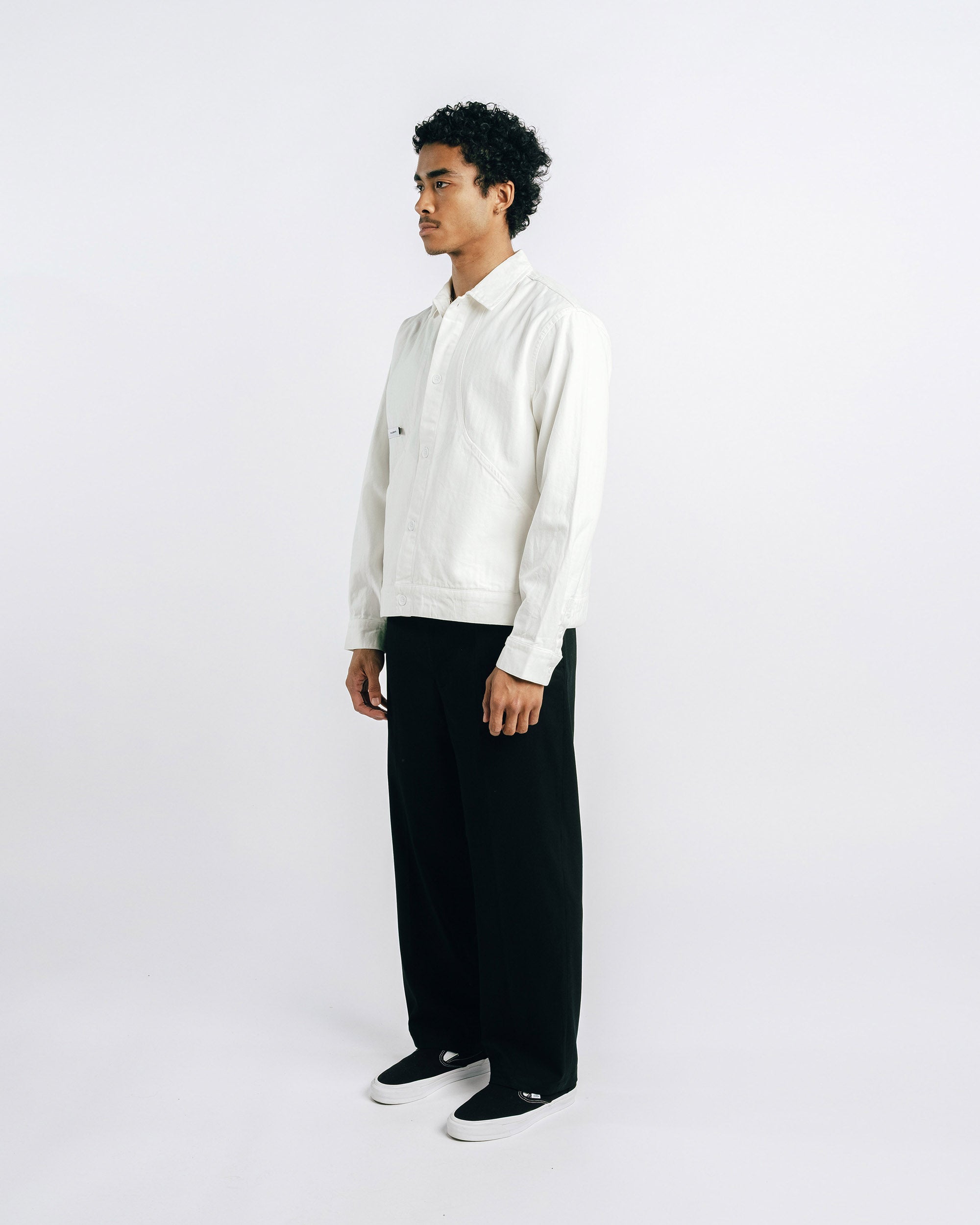 Man wearing a white shirt and black pants on a white background