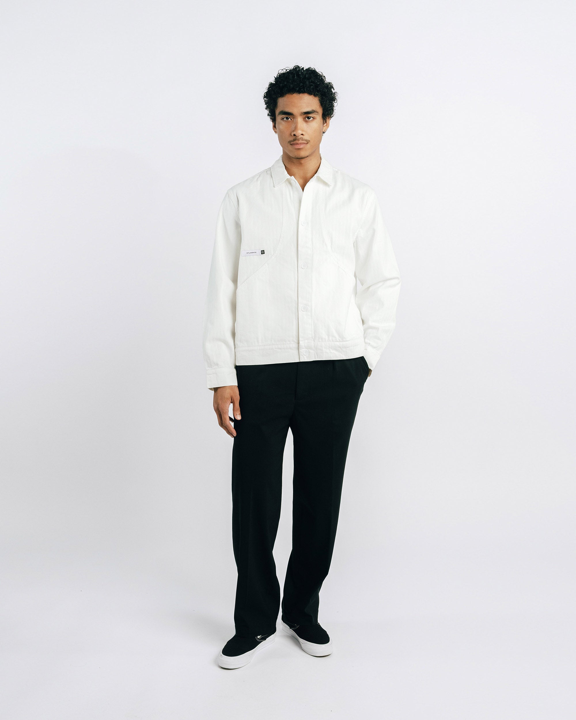 Man wearing a white shirt and black pants on a white background
