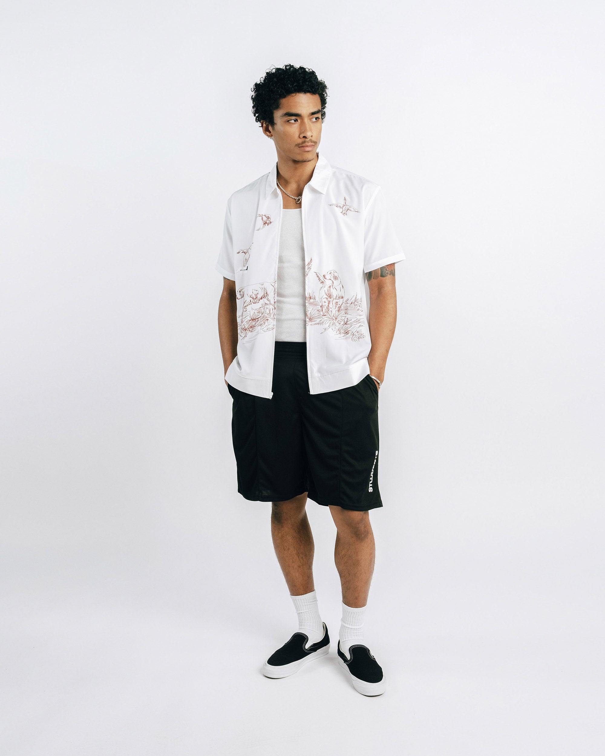 Person wearing a white shirt with black shorts on a white background