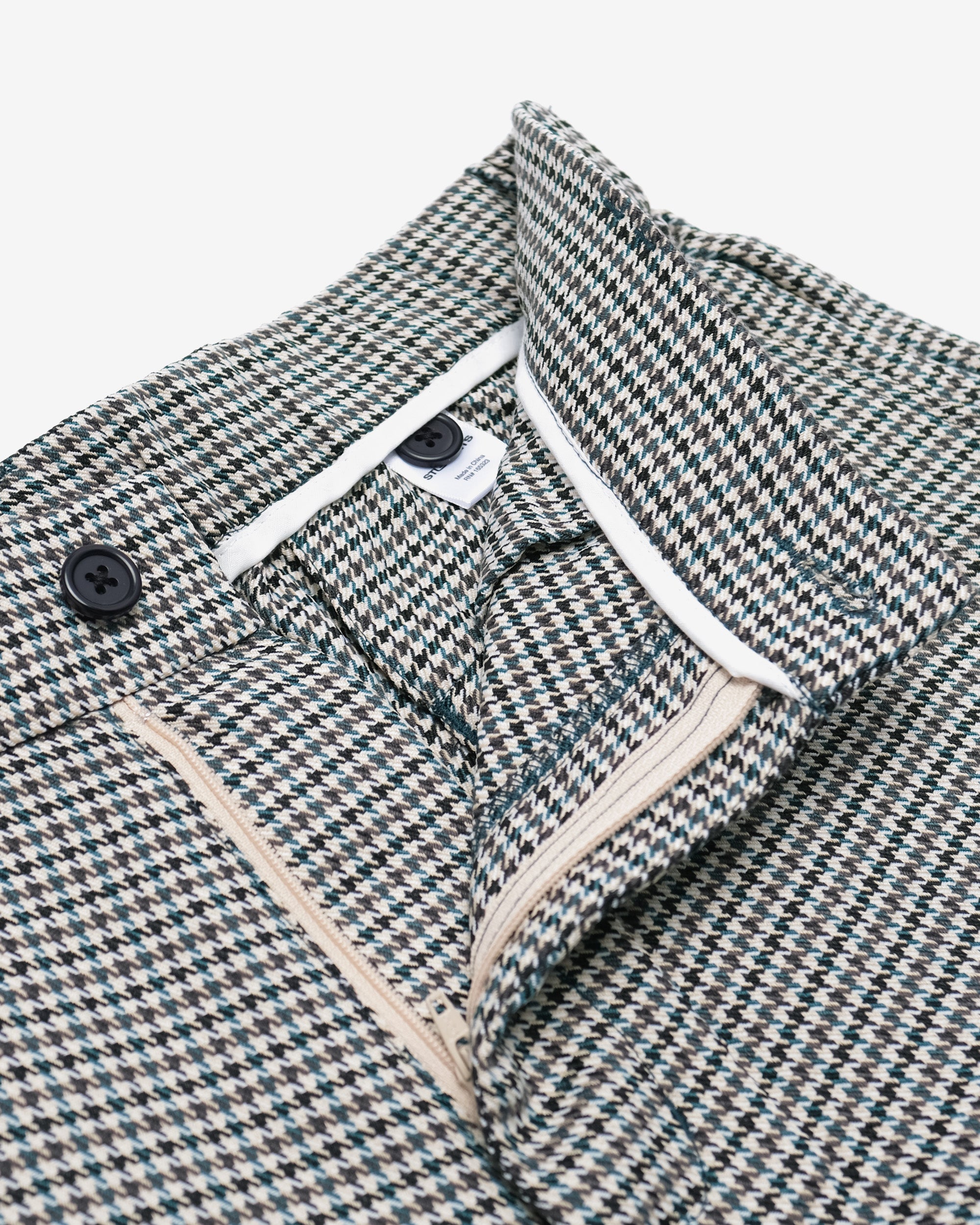 Houndstooth patterned shorts with white trim on a white background