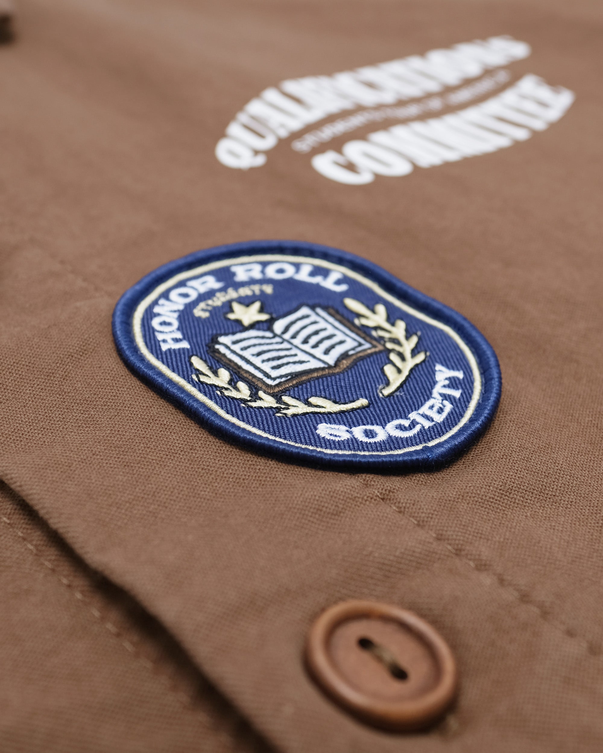 Brown jacket with 'Honor Roll Society' patch and button