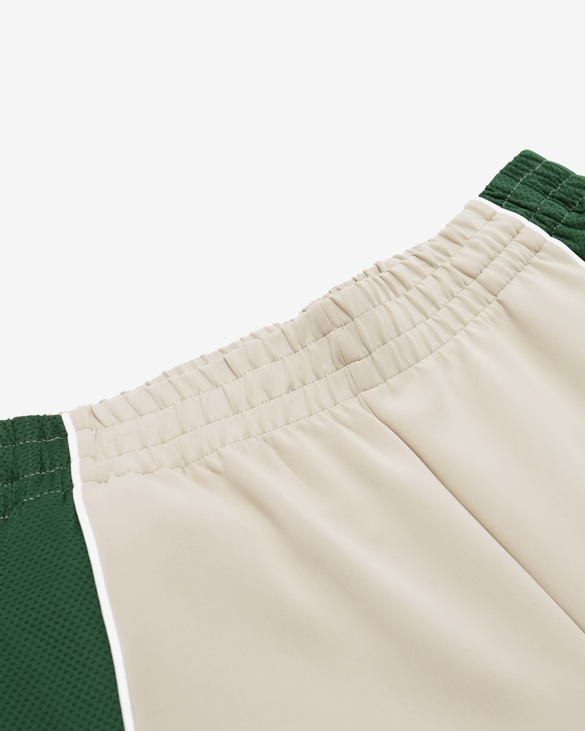 Close-up of beige pants with green accents on a white background