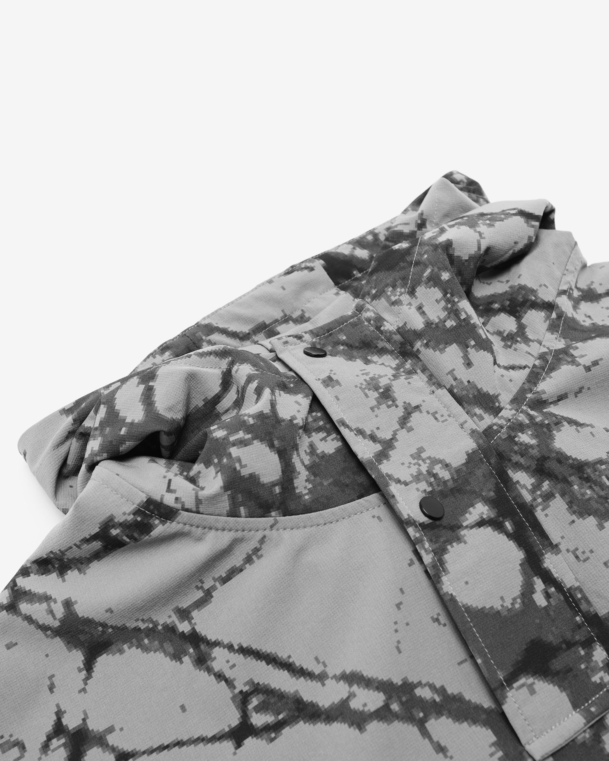 Folded camouflage-patterned jacket on a white background